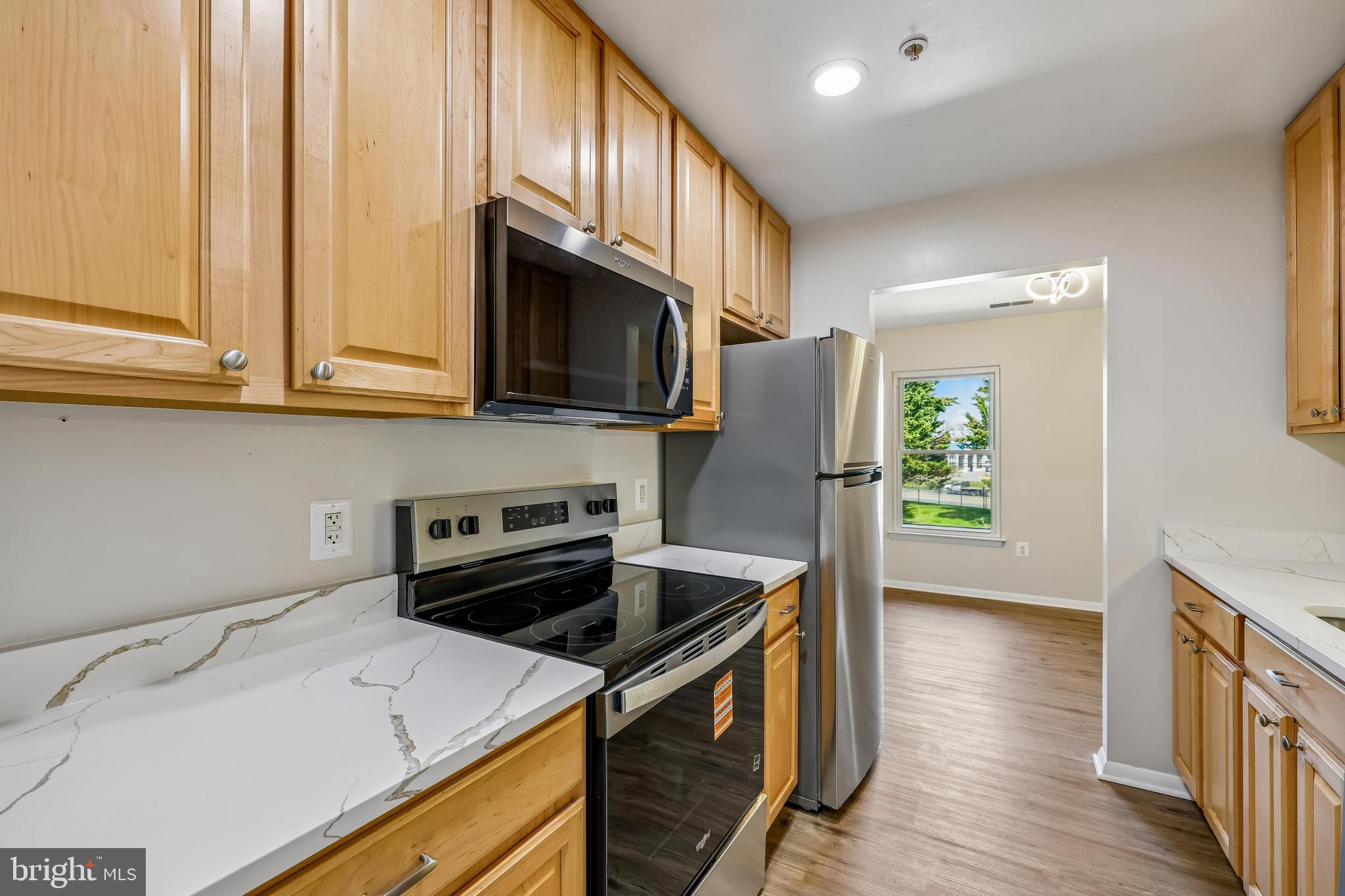 7804 Guildberry Court, Unit 301 Gaithersburg, MD 20879 - Photo 9 of 33 a kitchen with a sink a microwave a refrigerator and cabinets