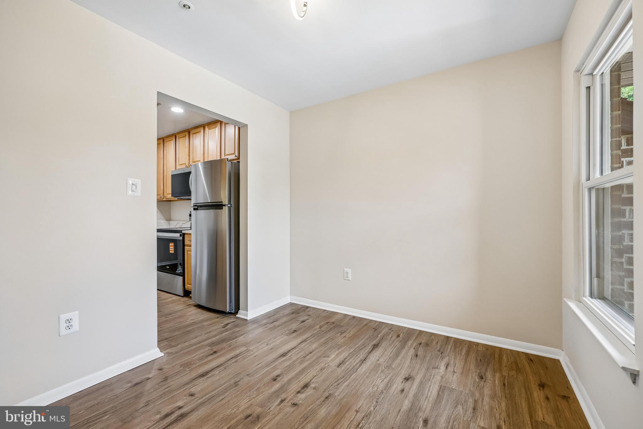 7804 Guildberry Court, Unit 301 Gaithersburg, MD 20879 - Photo 10 of 33 an empty room with wooden floor cabinet and windows