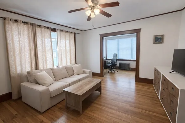 a living room with furniture and a wooden floor