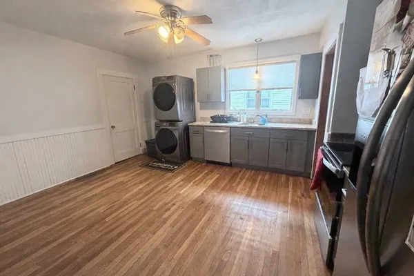 a hallway with wooden floor a table and chairs