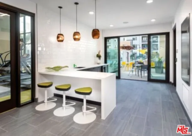 a living room with furniture kitchen view and a window