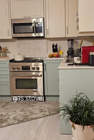 a kitchen with a stove a microwave and cabinets