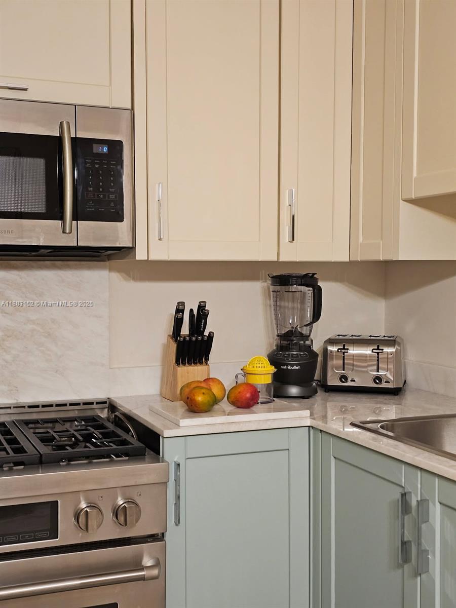 131 Zamora Avenue, Unit 2 Coral Gables, FL 33134 - Photo 5 of 17 a kitchen with a stove a microwave and cabinets