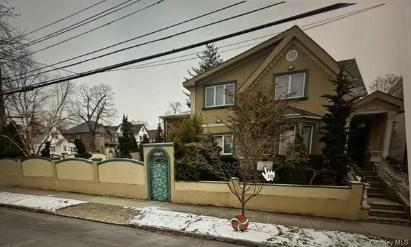 a front view of a house with a yard and trees