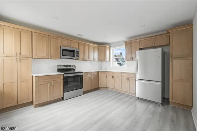 a kitchen with a refrigerator stove top oven and sink