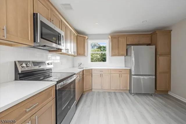 a kitchen with a sink a microwave a refrigerator and cabinets