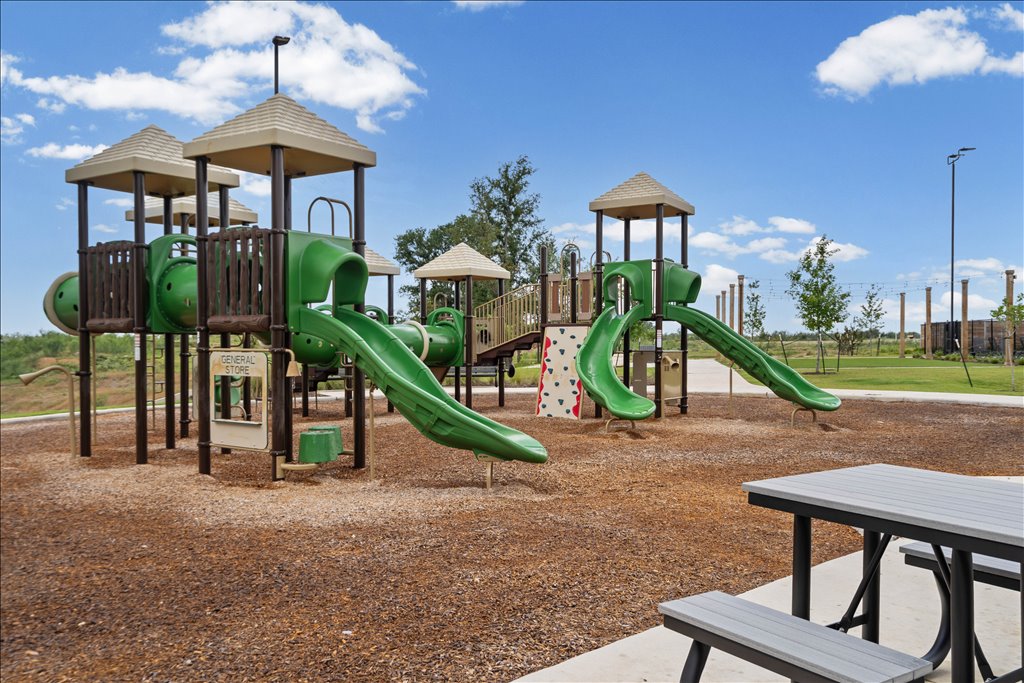 158 Gullivers Drive Elgin, TX 78621 - Photo 34 of 36 Just past the grills is a state-of-the-art playground structure. It’s got multiple slides, climbing walls, tunnels, and a shaded "general store" play window beneath.