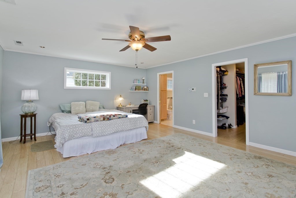 146 Huntington Road Russell, MA 01071 - Photo 28 of 42 a spacious bedroom with a large bed and a chandelier