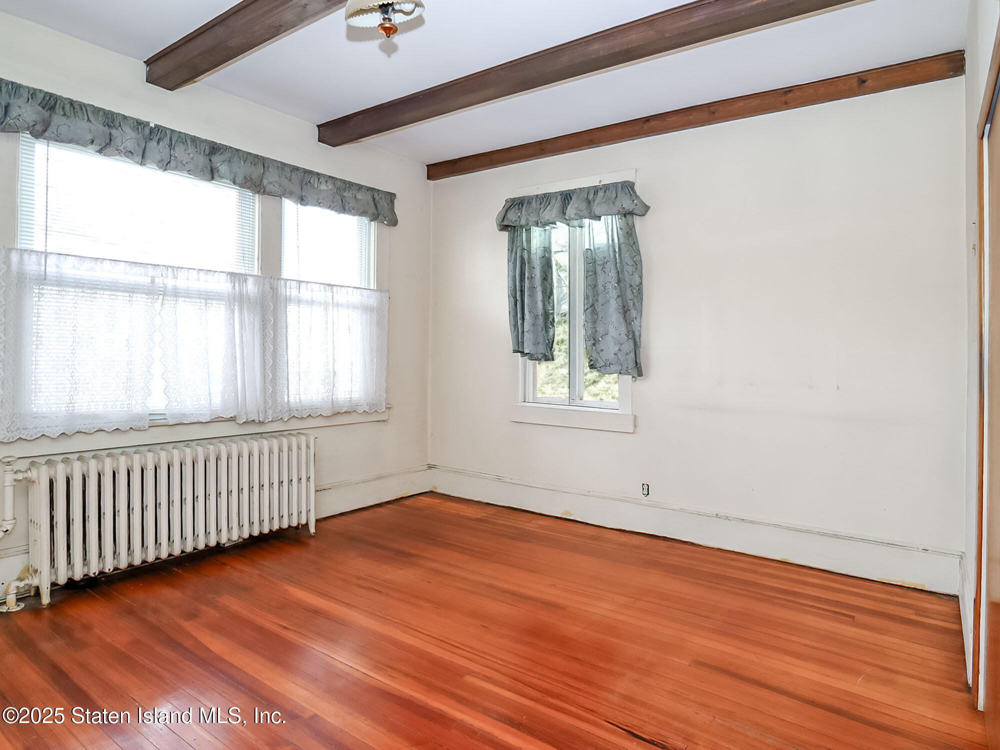 151 Clinton B Fiske Avenue Staten Island, NY 10314 - Photo 16 of 33 an empty room with wooden floor and windows