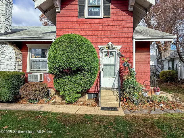 a front view of a house with a yard and plants