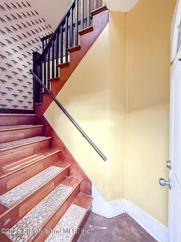 a view of staircase with wooden floor and a rug