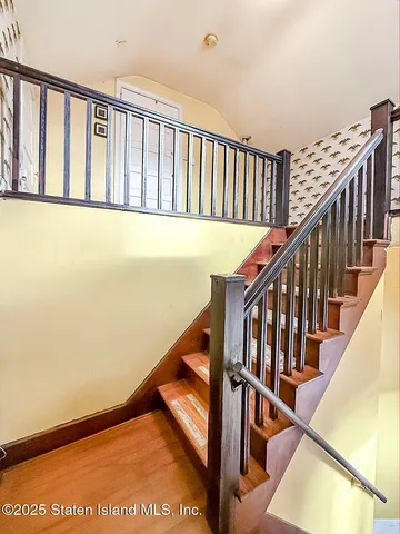 a view of staircase with railing and a window