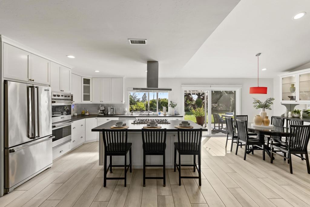 147 Witham Road Encinitas, CA 92024 - Photo 14 of 47 a dining area with stainless steel appliances a dining table chairs and wooden floor