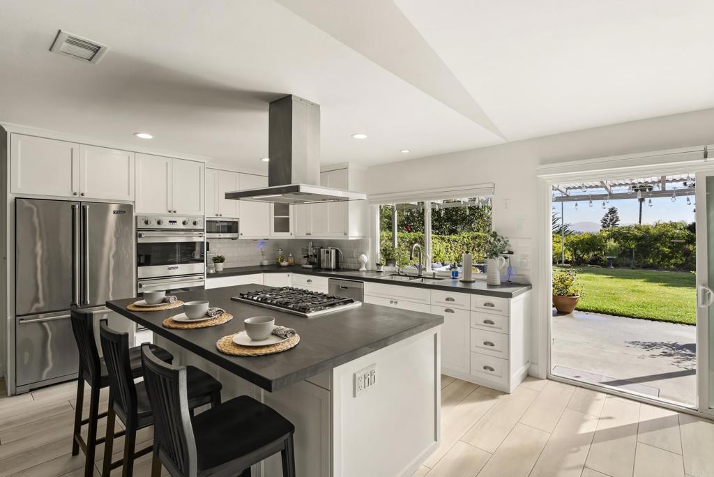 147 Witham Road Encinitas, CA 92024 - Photo 19 of 47 a kitchen with kitchen island a table and chairs in it