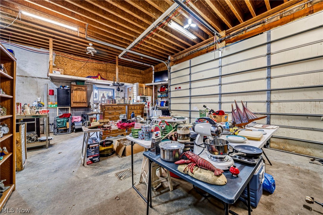 1050 Lake Road Conneaut, OH 44030 - Photo 29 of 39 HUGE Heated Garage with 12' ceilings, 10 ft door height, 3 bays, floor drains, electrical, workshop space, and its own half bath