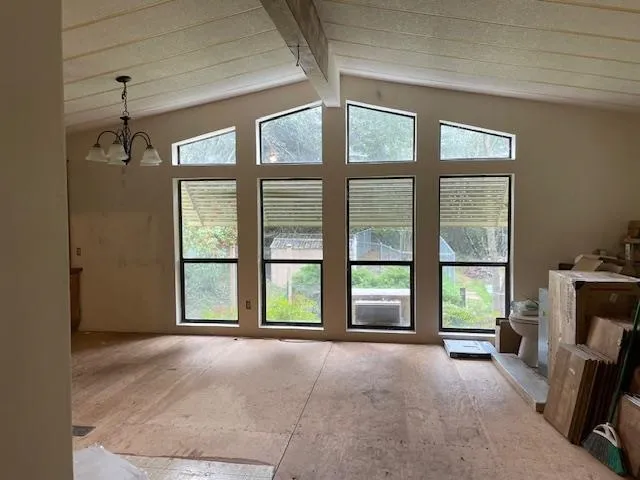 a view of an empty room with a fireplace and a window