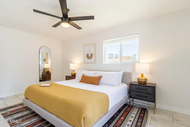 a bed sitting in a bedroom next to a window