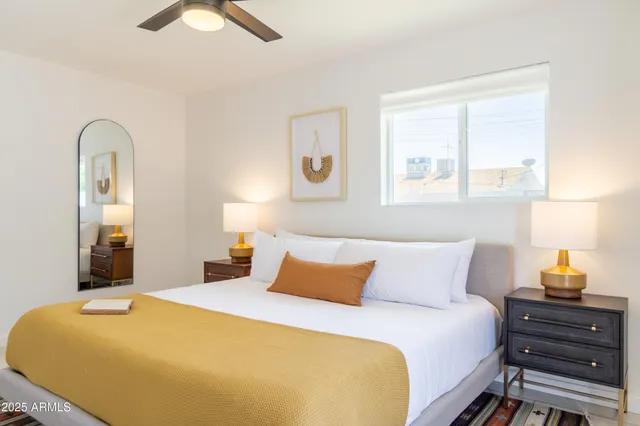 a bedroom with a bed and a painting on the wall