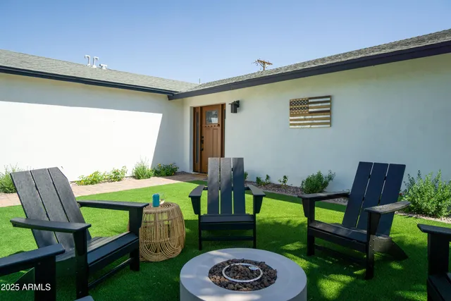 a kitchen with stainless steel appliances granite countertop a kitchen island a stove a refrigerator a sink a dining table and chairs