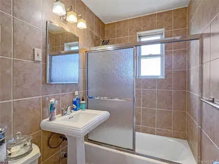 a bathroom with a sink mirror and a shower