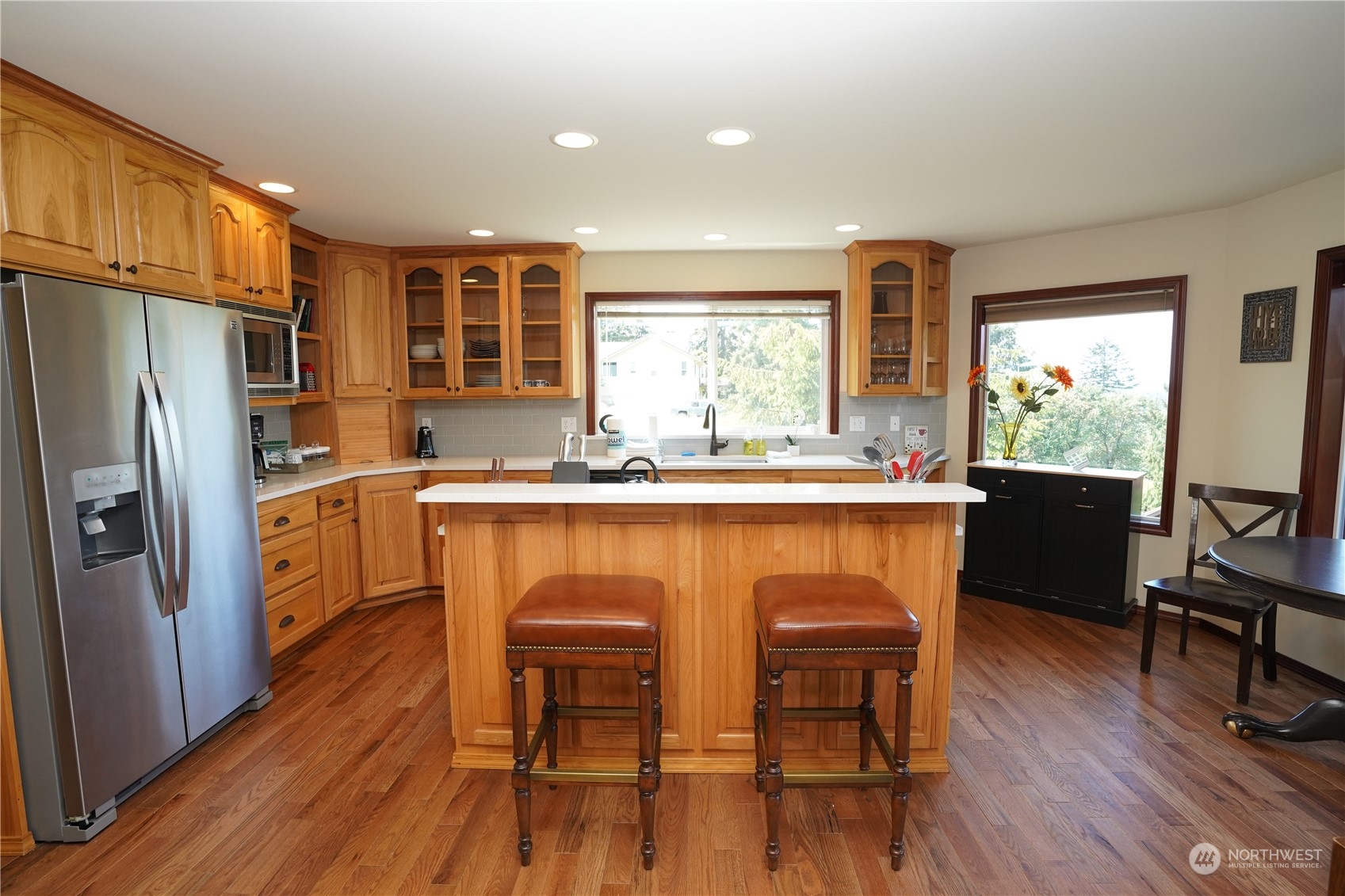 522 Fox Hollow Road Sequim, WA 98382 - Photo 7 of 40 a kitchen with a table chairs refrigerator and cabinets