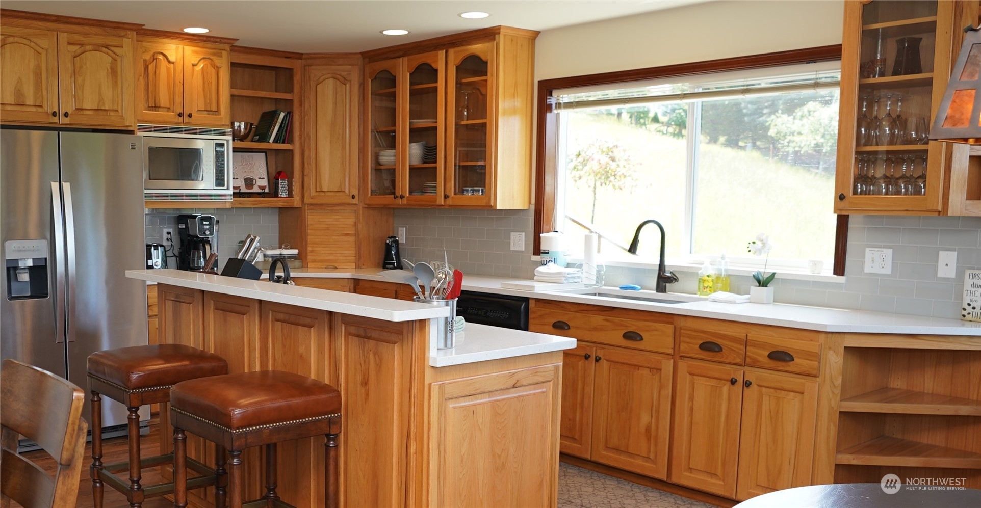 522 Fox Hollow Road Sequim, WA 98382 - Photo 8 of 40 a kitchen with stainless steel appliances granite countertop a refrigerator a sink dishwasher a stove and a dining table with wooden floor