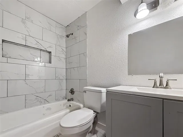 a bathroom with a sink toilet vanity and shower