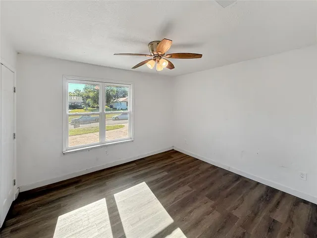 a view of a room with wooden floor and a window