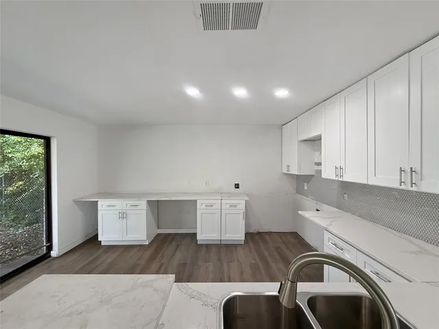 a view of a kitchen with fridge and wooden floor