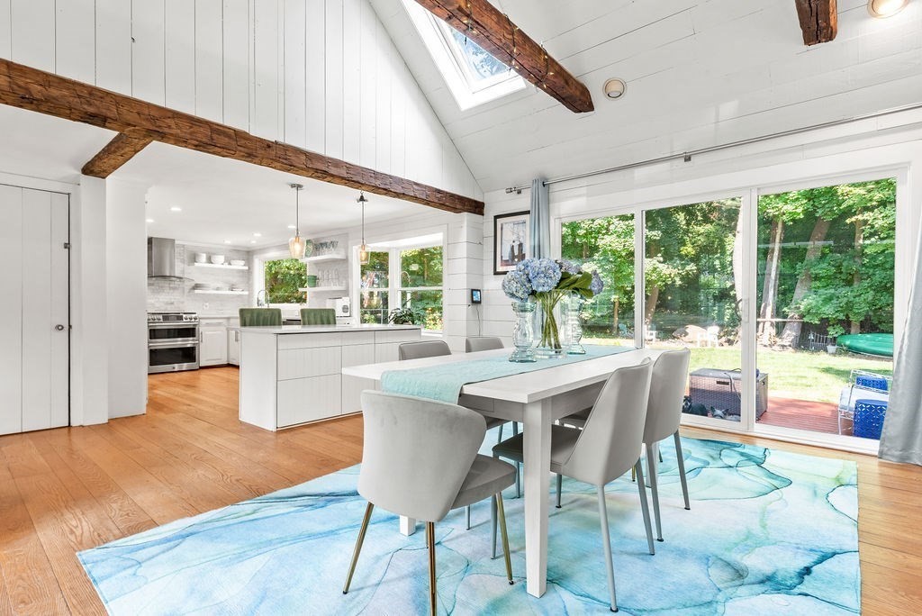 a dining room with furniture a rug and a floor to ceiling window