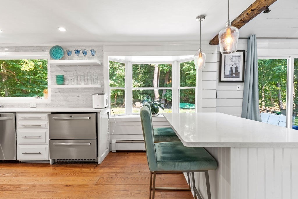 100 Circle Drive Wrentham, MA 02093 - Photo 14 of 42 a kitchen with kitchen island a stove a chimney and a large window