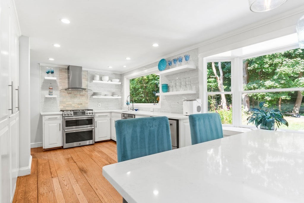 100 Circle Drive Wrentham, MA 02093 - Photo 8 of 42 a kitchen with granite countertop a stove a sink a refrigerator and a dining table with wooden floor