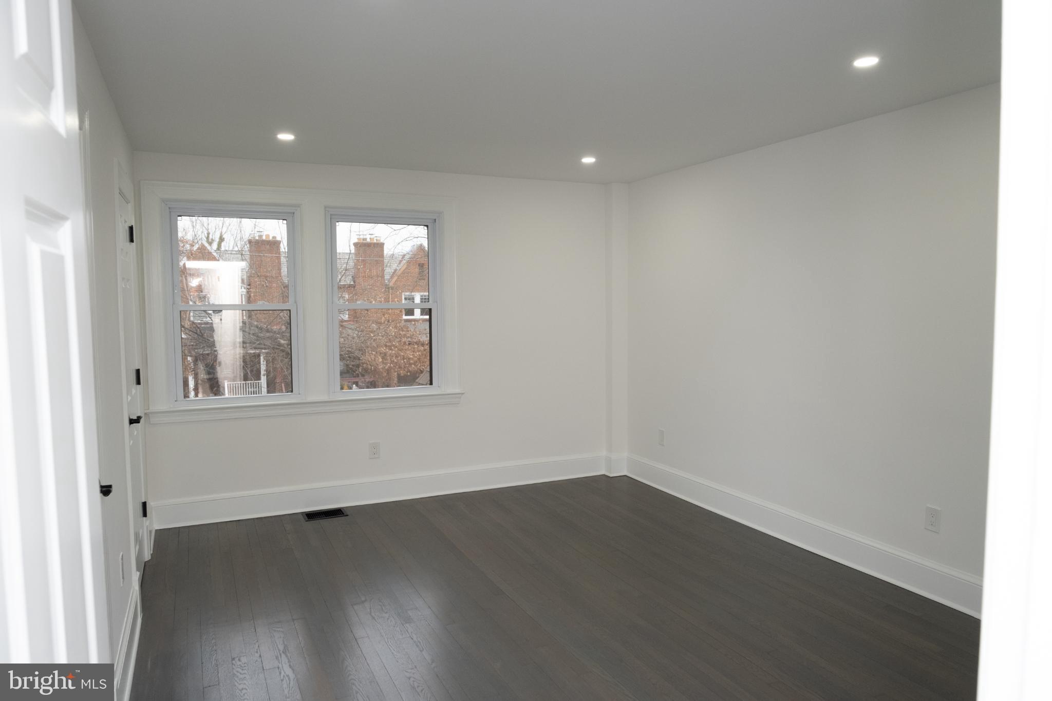 216 Jefferson Street Northwest, Unit A Washington, DC 20011 - Photo 17 of 32 an empty room with wooden floor and windows