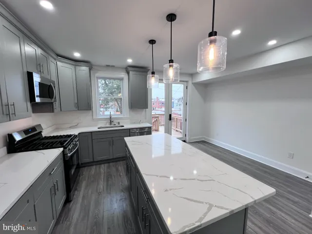 a large kitchen with kitchen island a large island in it