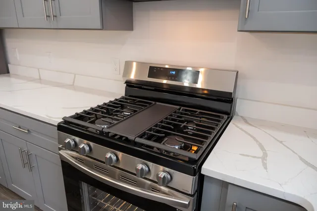 a stove sitting inside of a kitchen with white cabinets
