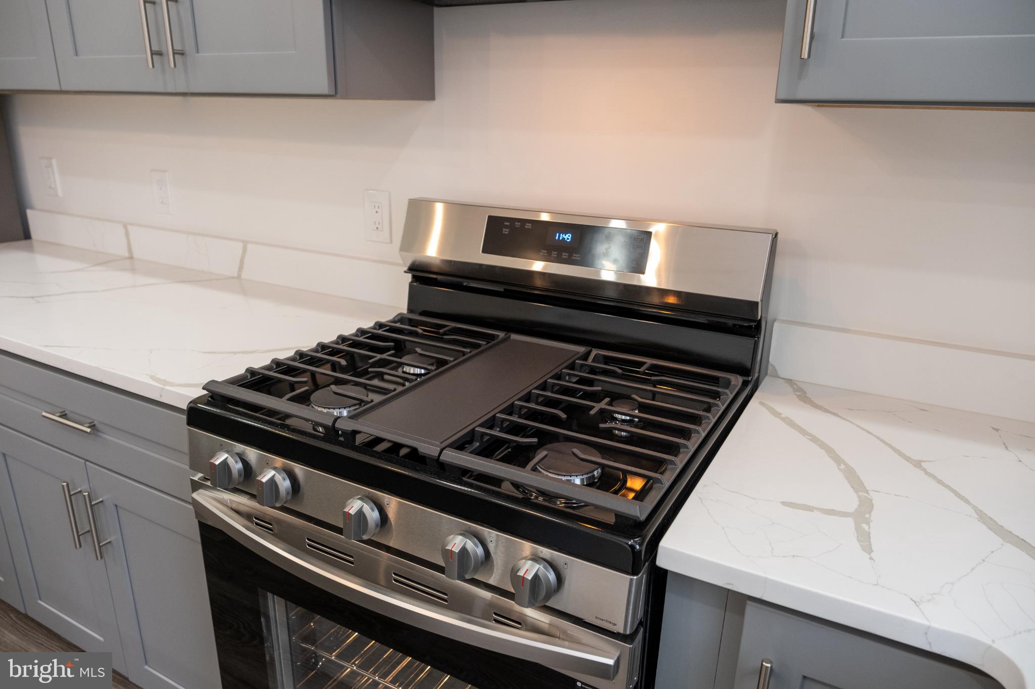 216 Jefferson Street Northwest, Unit A Washington, DC 20011 - Photo 8 of 32 a stove sitting inside of a kitchen with white cabinets