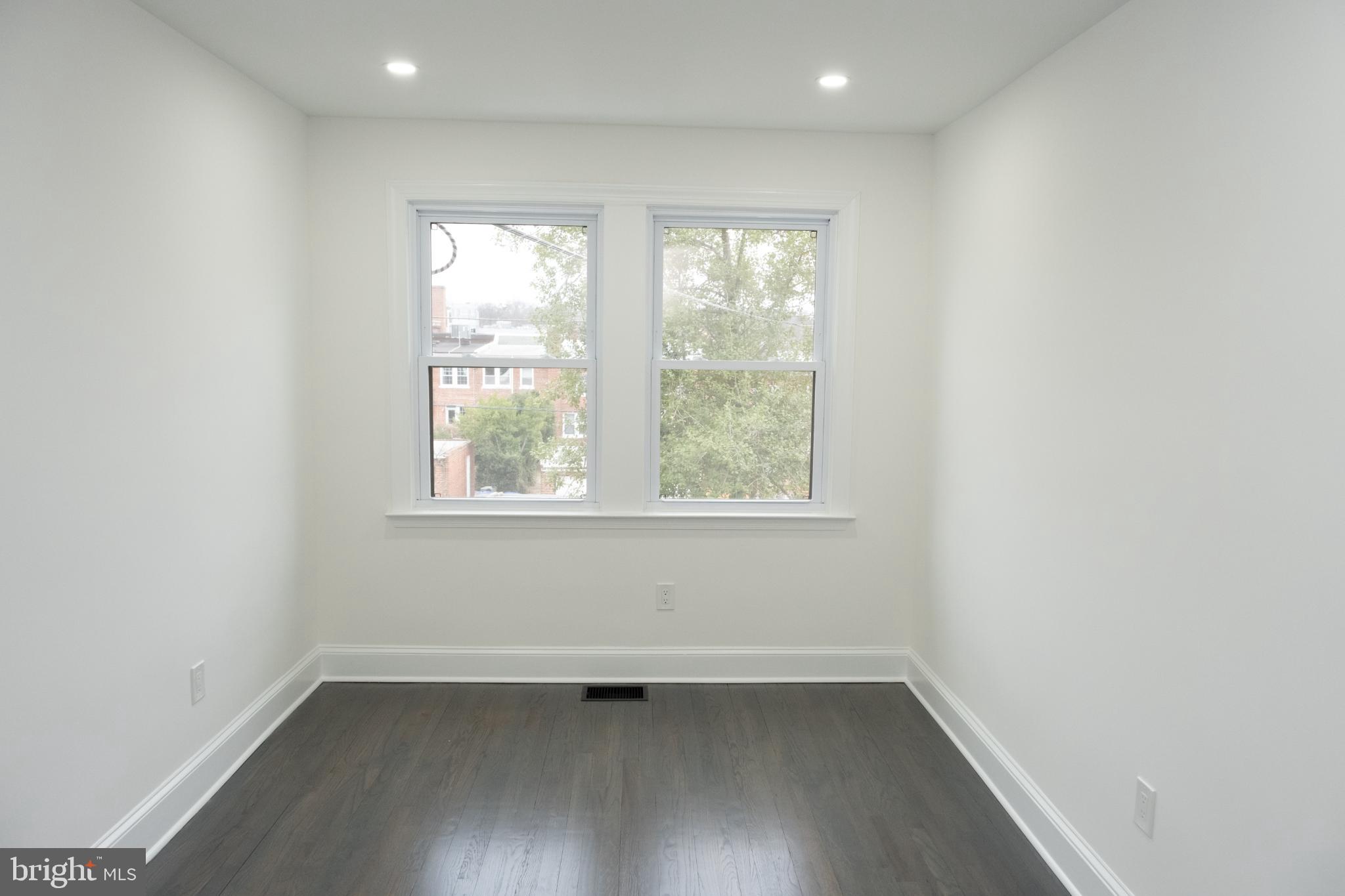 216 Jefferson Street Northwest, Unit A Washington, DC 20011 - Photo 9 of 32 an empty room with wooden floor and windows