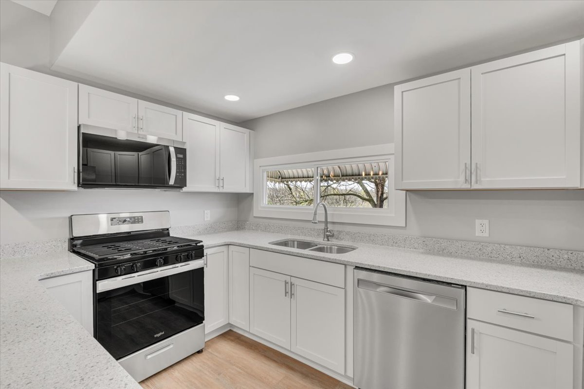 8850 Ridgewood Road Rock Island, IL 61201 - Photo 11 of 45 a kitchen with stainless steel appliances granite countertop white cabinets a stove a sink and dishwasher