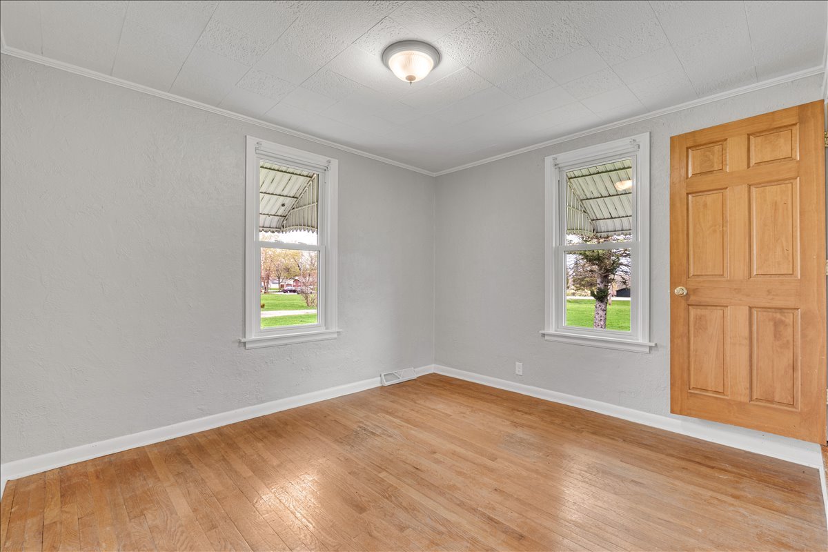 8850 Ridgewood Road Rock Island, IL 61201 - Photo 22 of 45 a view of an empty room with wooden floor and a window