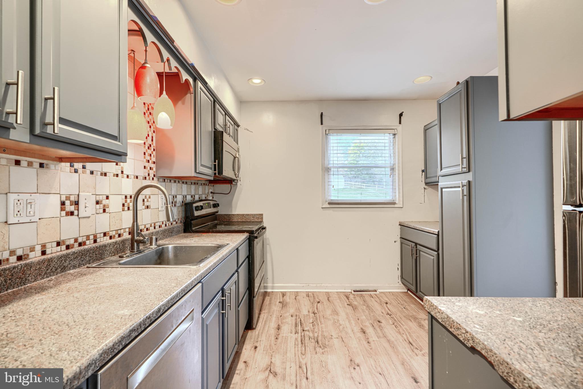 1167 Long Valley Road Westminster, MD 21158 - Photo 12 of 36 a kitchen with stainless steel appliances granite countertop a sink stove and refrigerator
