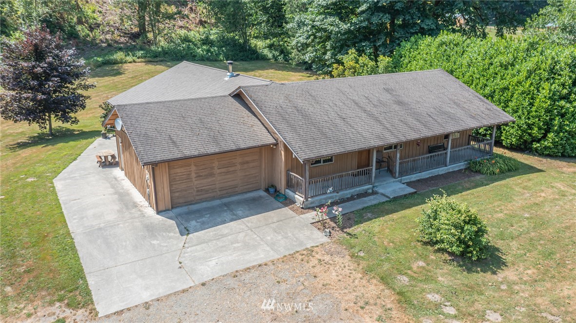 an aerial view of a house with swimming pool next to a yard