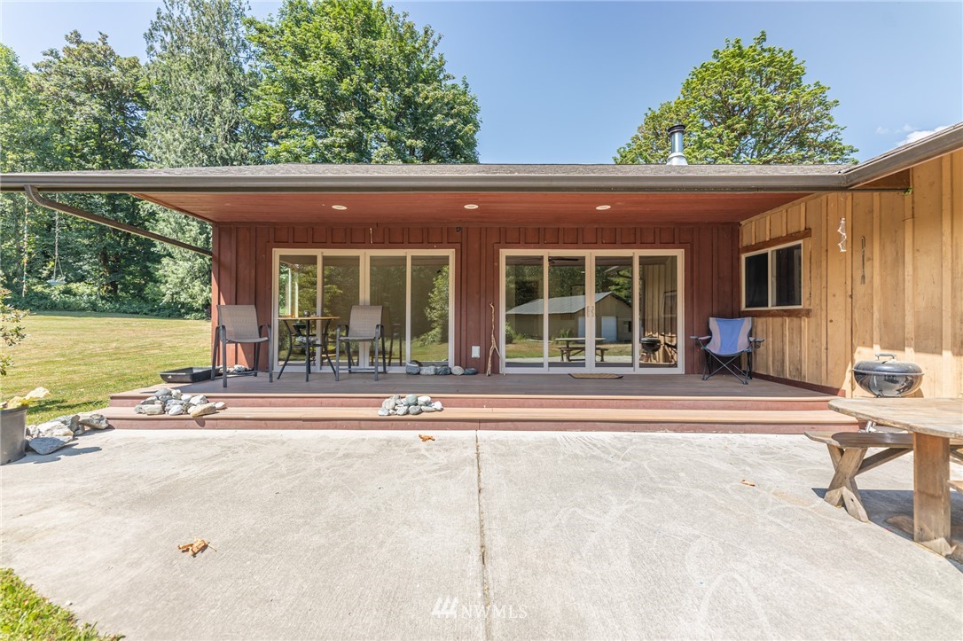 50332 Concrete Sauk Valley Road Concrete, WA 98237 - Photo 27 of 40 a view of a patio with table and chairs and floor to ceiling window