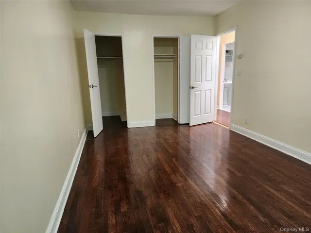 an empty room with wooden floor and closet