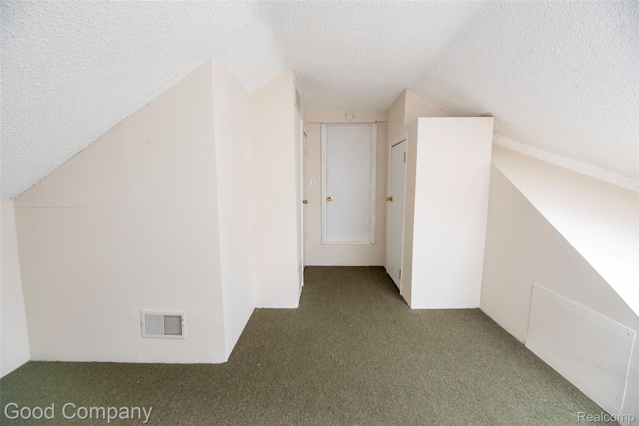 3685 Cone Avenue Rochester, MI 48309 - Photo 17 of 23 Sloped ceiling design, textured ceiling finish, wall-to-wall carpet, two white interior doors, and a built-in wall panel