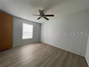 5416 Miley Road Plant City, FL 33565 - Photo 19 of 19 an empty room with wooden floor fan and windows