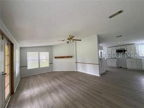 5416 Miley Road Plant City, FL 33565 - Photo 9 of 19 an empty room with wooden floor kitchen view and windows