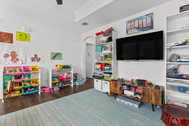 a children room with furniture and a flat screen tv