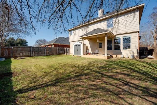 a view of a house with a yard patio and fire pit