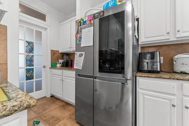 a kitchen with stainless steel appliances granite countertop a refrigerator and a stove top oven