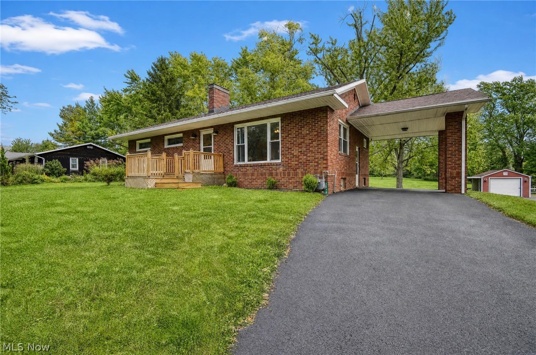3864 State Road South Ashtabula, OH 44004 - Photo 1 of 50 Brick exterior with a covered carport, paved driveway, and natural wood deck